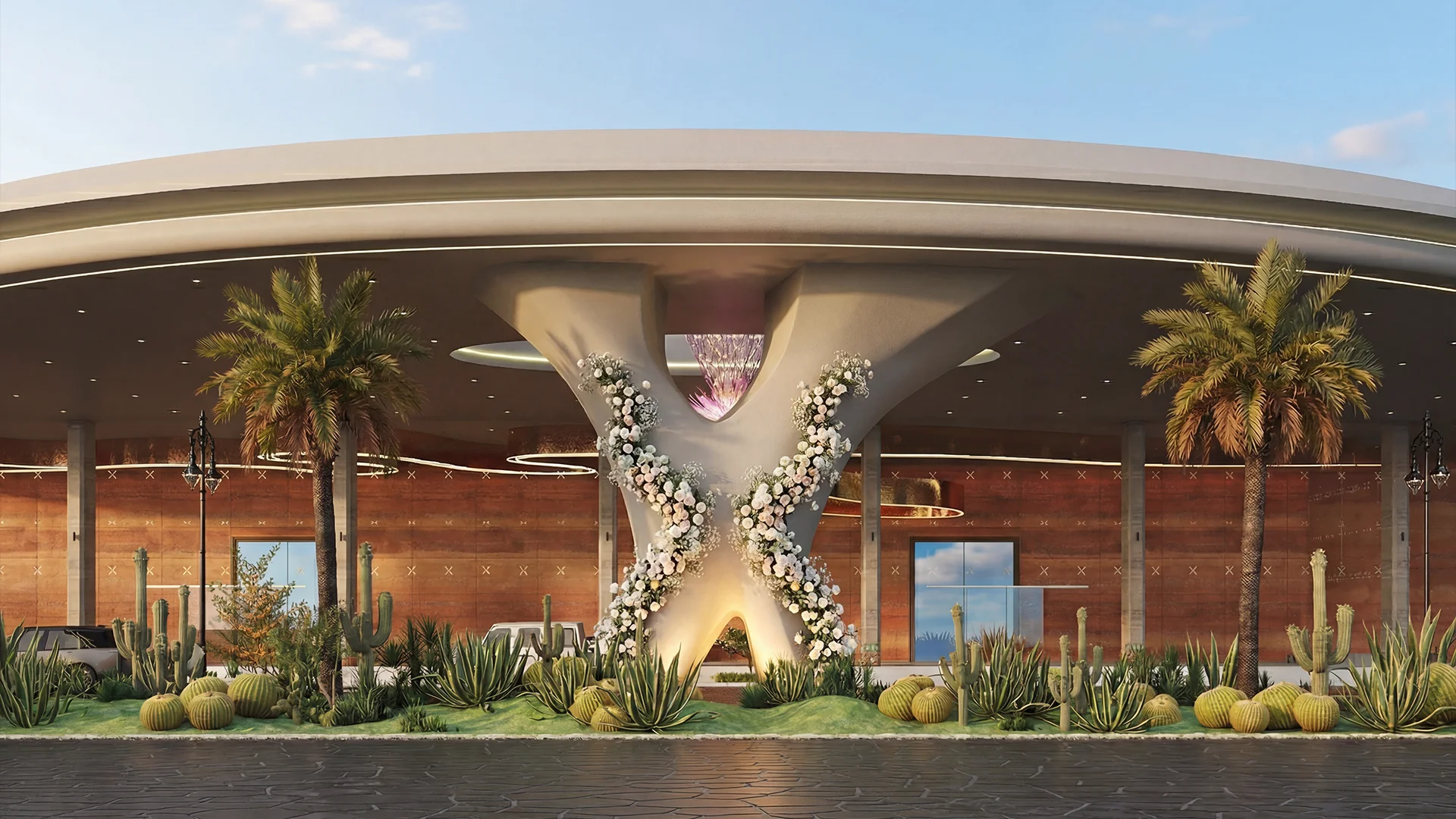 Eventara X-column entrance lit at night with palms and stone path