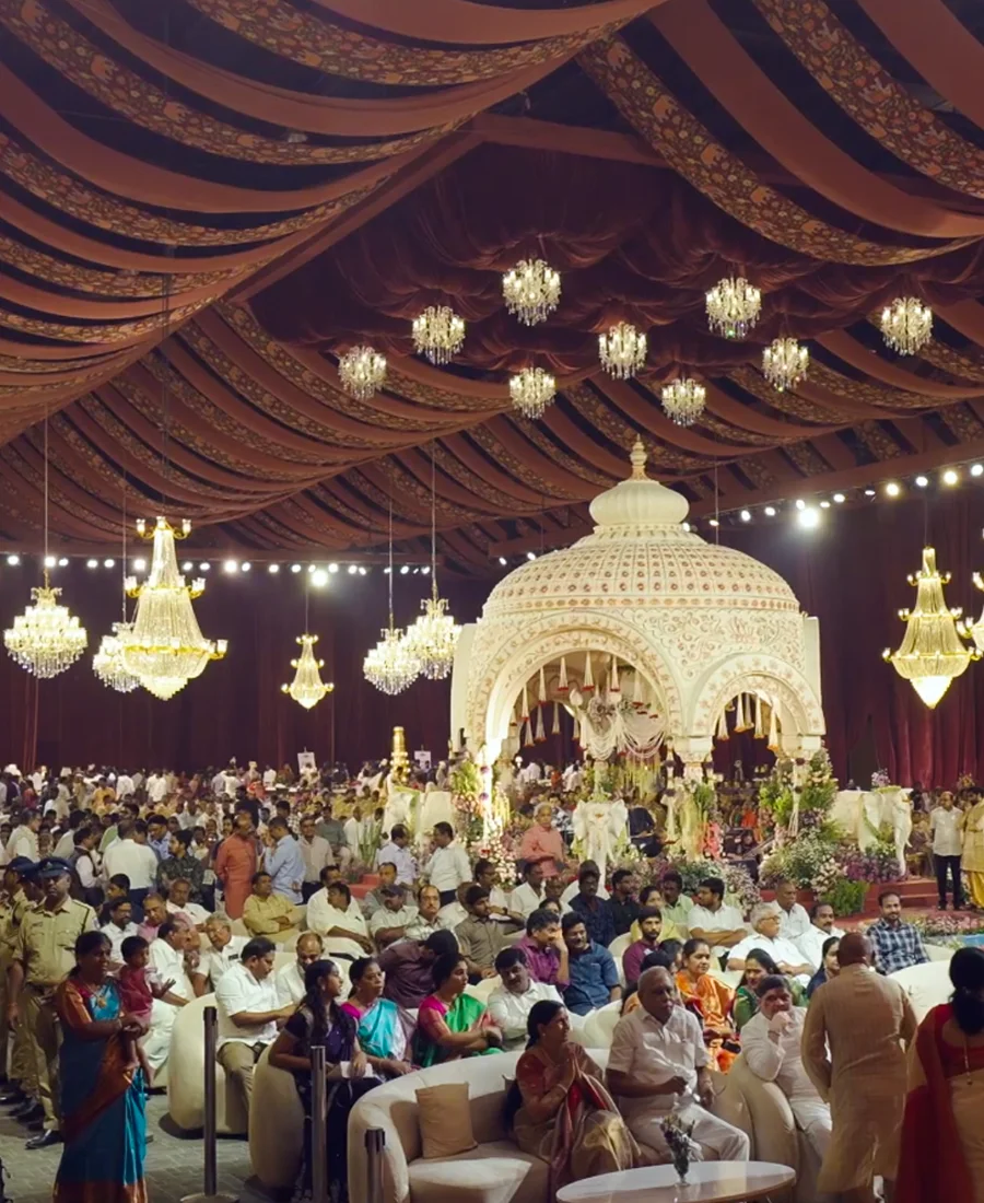 Decorated wedding mandap at Eventara with sage and blush draped ceiling, chandeliers, and guests seated for the ceremony